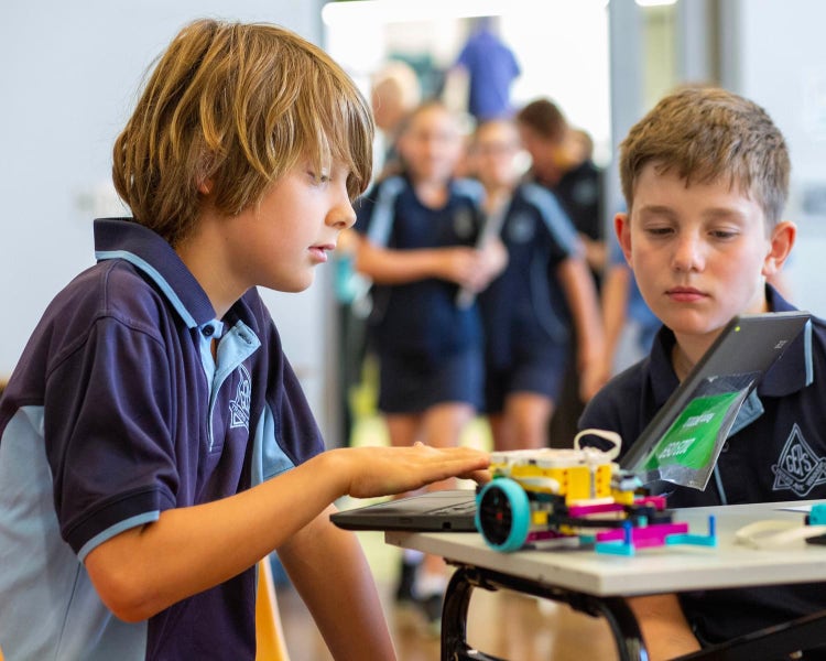2 boys looking at a computer with extreme concentration