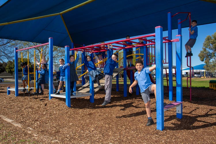 students playing on the K-2 playground equipment