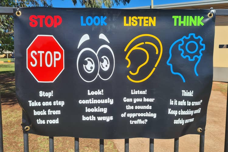 a sign on the fence saying 'stop, look, listen and think'